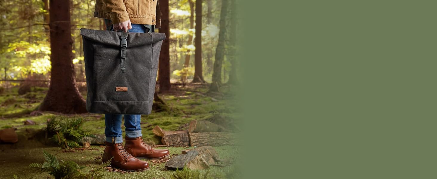 Person holding backpack from the top on a forest