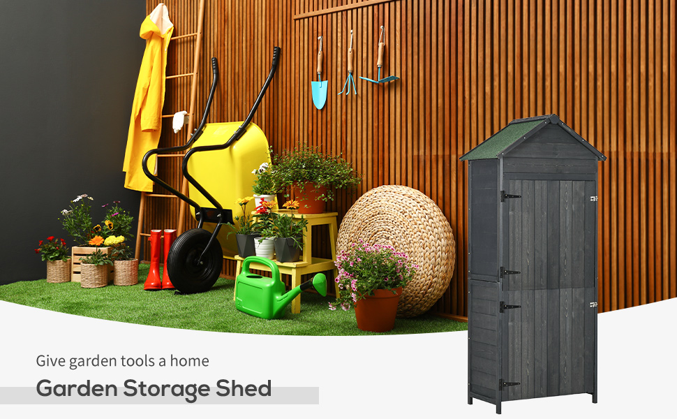 Grey outdoor garden storage shed displayed alongside gardening equipment and tools against wooden fence backdrop.