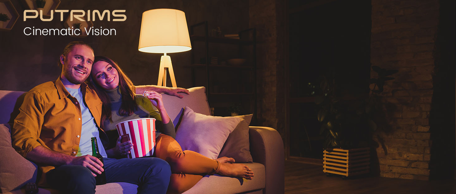 two people sitting on a couch and eating popcorn