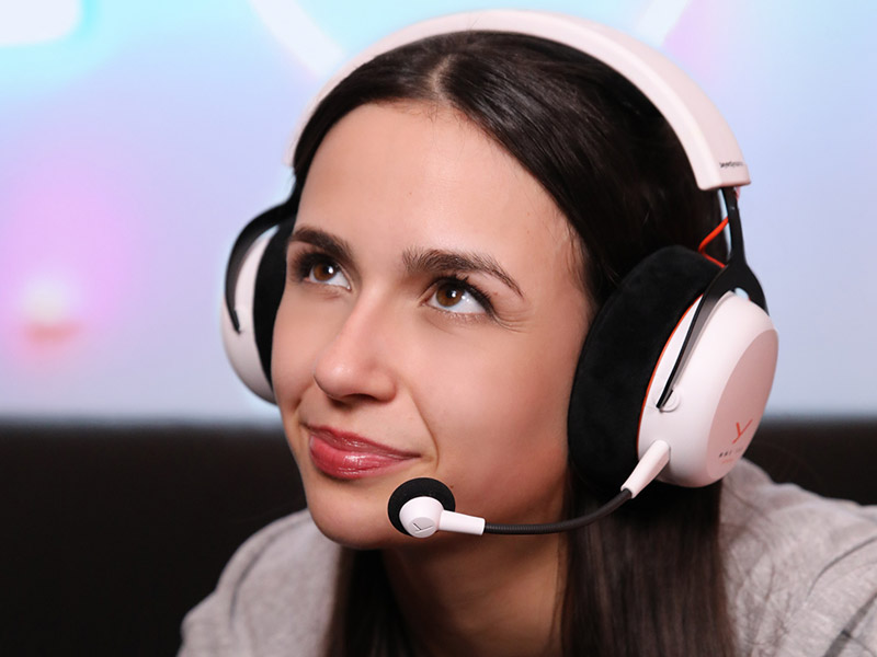 Person wearing white gaming headset with microphone in multiple views against light blue background.
